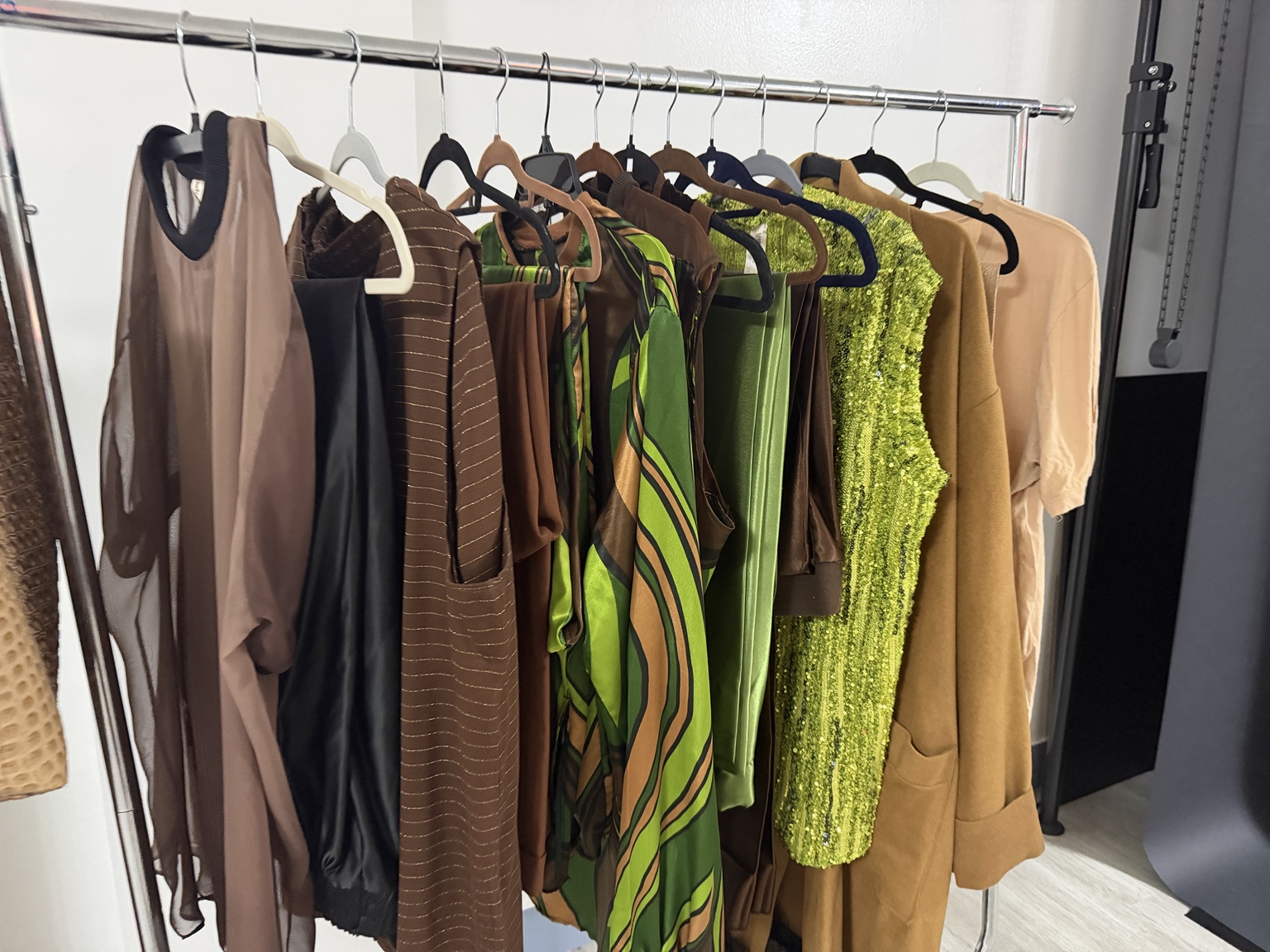 Custom garments in green, brown, gold and black on the house wardrobe rack